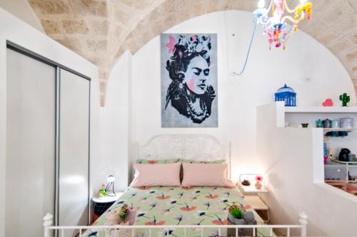 布林迪西Vivalavida的卧室配有一张床,墙上挂有绘画作品