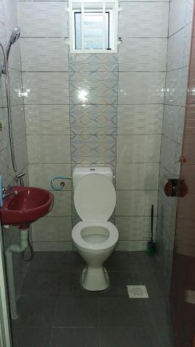 Paya Rewak达雅因迪娜民宿的一间带卫生间和红色盥洗盆的浴室