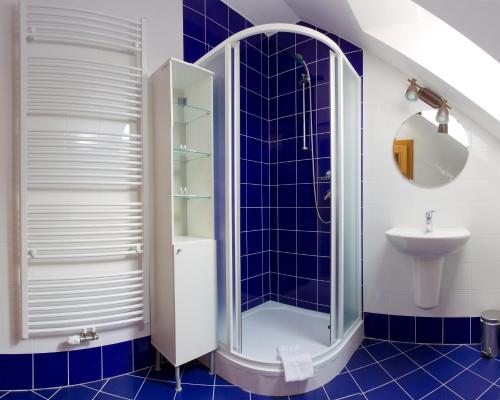 库特纳霍拉哈维斯卡布达酒店的蓝色瓷砖浴室配有淋浴和盥洗盆