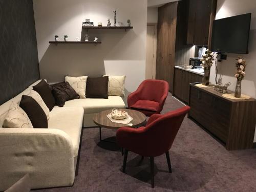 科帕奥尼克Joy Apartman Kula Konaci的客厅配有白色沙发和红色椅子