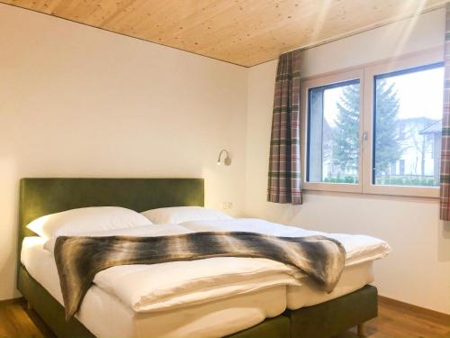 克勒施特勒Woodpecker Chalets的一间卧室配有一张带绿色床头板的床和窗户