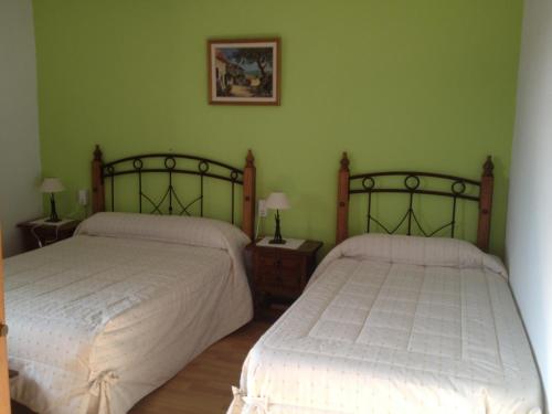 Catí马斯维尔乡村民宿的卧室设有两张床铺和绿色的墙壁