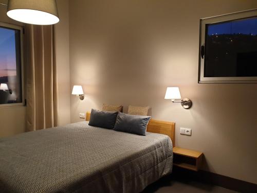 里韦拉布拉瓦Casa Atlantico Dachterrassengeschoss的一间卧室配有带两个枕头的床和窗户