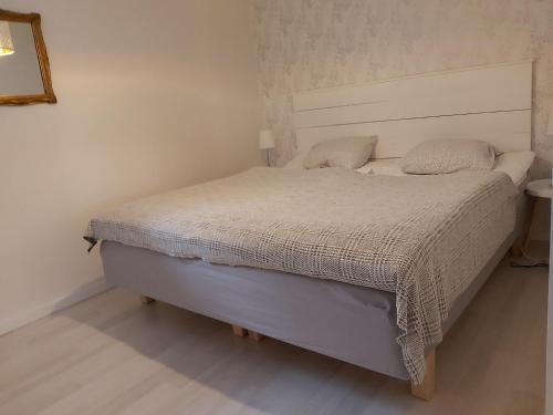 斯特伦斯塔德Cottage Langan的一间卧室配有一张带白色床罩的床