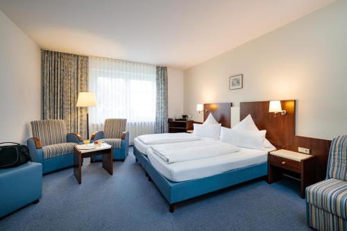 库克斯港燕鸥酒店的酒店客房,配有一张床和两把椅子