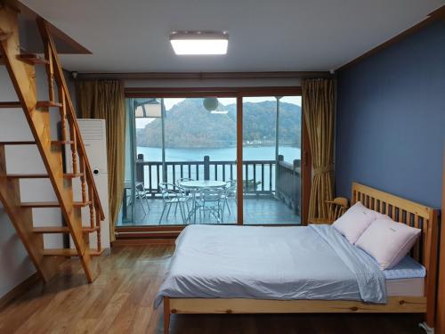 春川LaHoya Pension的一间带梯子和床的卧室以及一个阳台