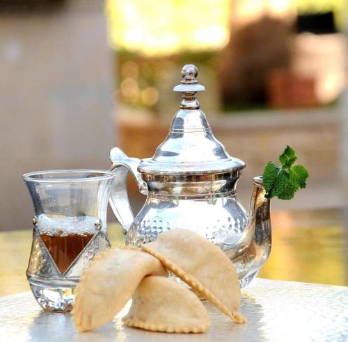 Ait MelloulHotel Ribis的玻璃茶壶和一碗茶及薯条