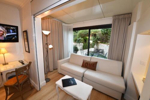 戛纳普罗旺斯酒店的客厅配有白色沙发和窗户