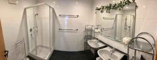 因斯布鲁克Ferienwohnung Schranz的浴室设有2个盥洗盆、淋浴和2面镜子。