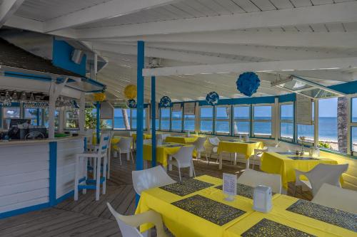 拉斯特拉纳斯考斯塔热纳海滩酒店的餐厅设有黄色桌子和白色椅子