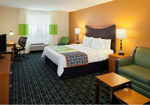 费耶特维尔Country Inn & Suites by Radisson, Fayetteville I-95, NC的酒店客房设有一张大床和一张沙发。