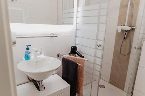 盖尔森基兴SK Apartments - Blue的白色的浴室设有水槽和淋浴。