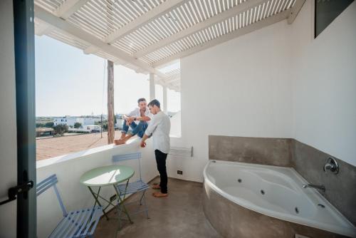 纳克索乔拉圣瓦拉西斯酒店的两人站在带浴缸的浴室