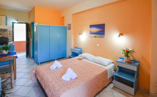 贝尼蔡斯Panos Apartments的一间卧室配有一张床和一个蓝色的橱柜