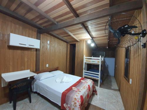 卡庞达卡诺阿Residencial Rei Thomas的一间卧室配有一张床、一张桌子和风扇