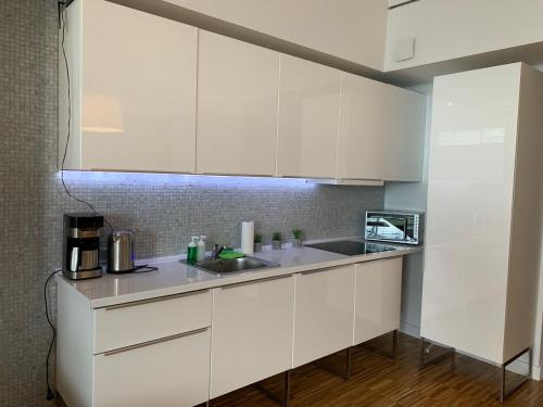 尤斯托尼莫斯基Apartament na Klifie DUNE的厨房配有白色橱柜和水槽