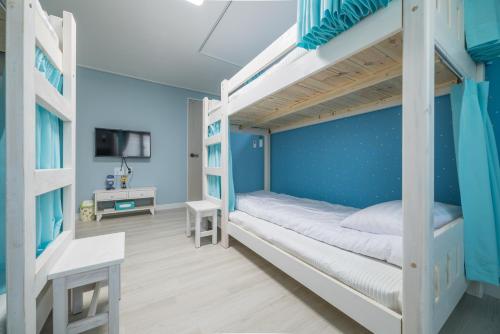 仁川市梦之旅旅馆的一间卧室配有带蓝色墙壁的双层床