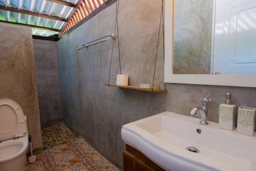 Tha Lane Bay香蕉度假酒店及餐厅的一间带水槽、卫生间和镜子的浴室