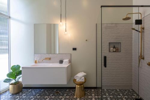 但尼丁The Burlington Luxury Octagon Apartment的浴室配有浴缸、淋浴和水槽