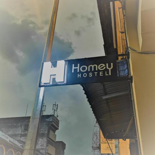 怡保Homey Hostel的大楼一侧蜂蜜旅馆标志