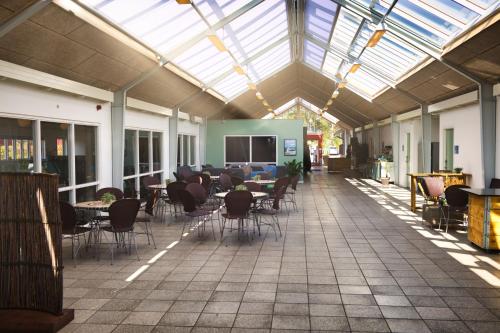 伊肖伊伊士基丹麦埃索酒店的一间设有桌椅和玻璃天花板的自助餐厅