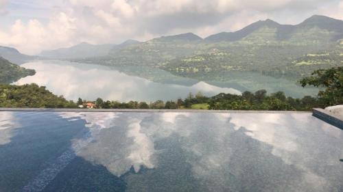 浦那The Green Gate Resort Mulshi的享有湖泊和山脉景致的游泳池