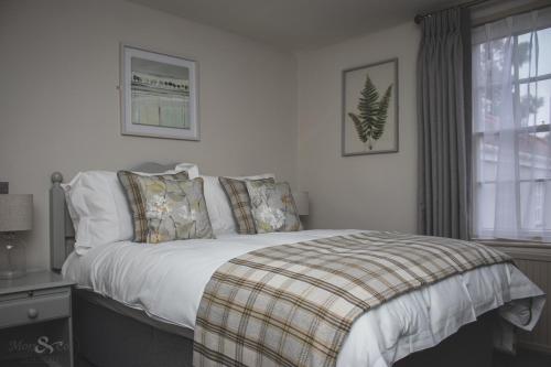WangfordThe Angel Inn的卧室配有带枕头的床铺和窗户。