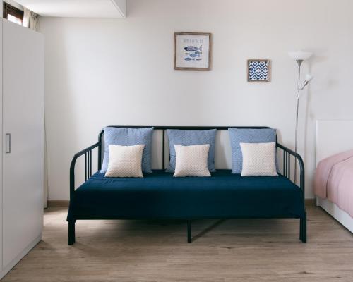 丰沙尔BINIS Apartment的卧室内带枕头的蓝色长椅