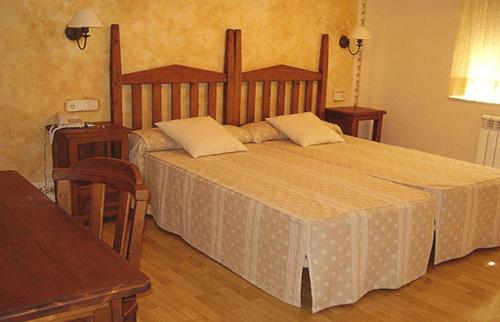 Peñausende拉贝切拉酒店的一间卧室配有一张大床和两个枕头