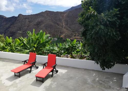 埃尔米瓜Casa Lita的阳台上配有两把红色椅子,享有山景