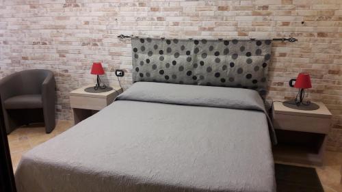 萨萨里Lamarmora 58的一间卧室设有一张床和砖墙