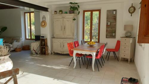 尼翁Le Ptit Cottage的一间带桌子和红色椅子的用餐室