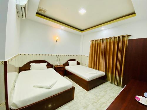 戈公戈公纳西酒店的酒店客房设有两张床、一张桌子和一张书桌。