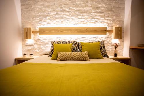 塞拉内华达Nirvana的一间卧室配有一张黄色的床和砖墙