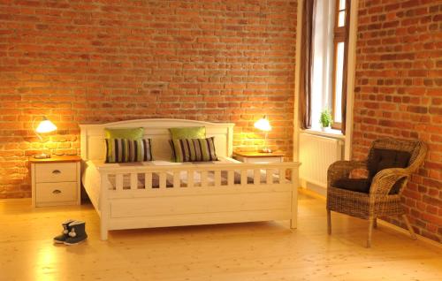 普日布拉姆时光咖啡旅馆的一间卧室设有一张床和砖墙