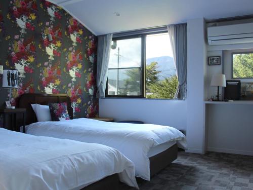 轻井泽维利斯酒店的酒店客房设有两张床和窗户。