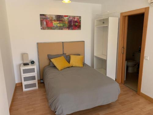 阿尔考空Apartamento de 1 dormitorio, Ático 4PAX的一间卧室配有一张带两个黄色枕头的床