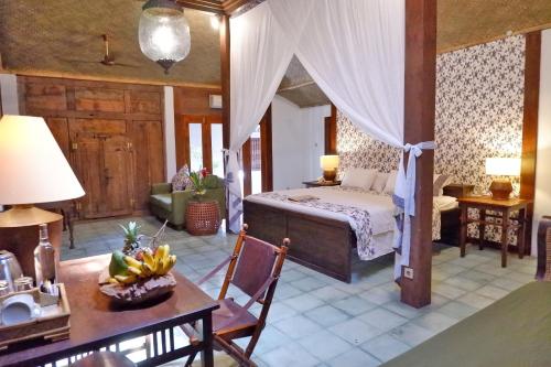 日惹德欧玛日惹酒店的一间卧室配有一张床和一张桌子,上面放有香蕉