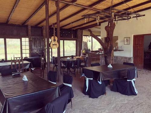 蒂诺加斯塔Hotel Hacienda Casa Blanca的一间带桌椅和吉他的餐厅