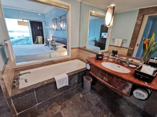 新山提斯特尔的一间带大镜子、浴缸和床的浴室