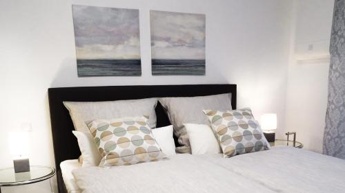 鲁斯特Boland Apartments的卧室配有一张墙上有两张照片的床。