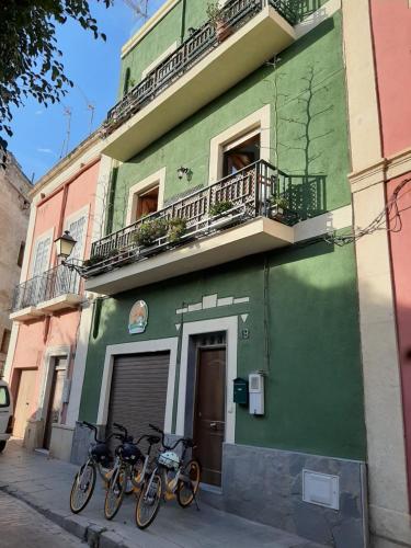 阿尔么丽亚La Pita Guesthouse的两辆自行车停在绿色建筑外