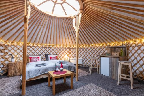 罗瓦涅米Yurt District的蒙古包内一间卧室,配有一张床和一张桌子