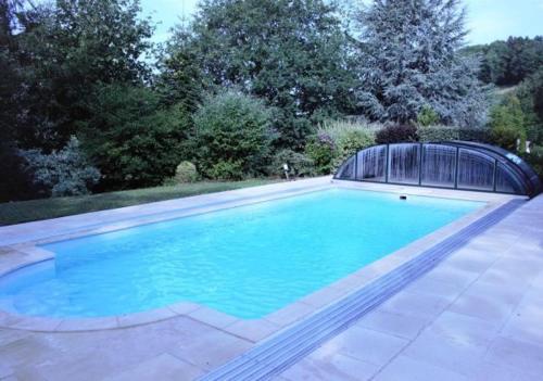 托朗格利耶尔Le chalet des Pesettes的庭院内带遮盖的大型游泳池