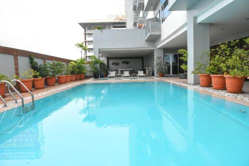 宿务艾丽西亚公寓式酒店的大楼内的一个蓝色海水游泳池