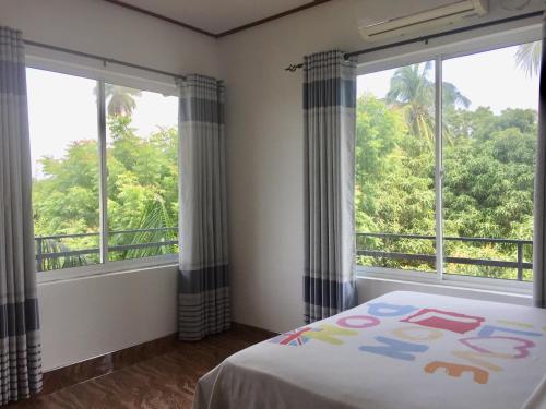 波隆纳鲁沃特萨拉宾馆的一间卧室设有2扇窗户和1张带床罩的床