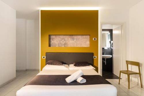 马帝斯兹罗Hotel Mediterraneo -Spiaggia Ombrelloni e Lettini Inclusi-的一间卧室设有一张黄色墙壁的大床