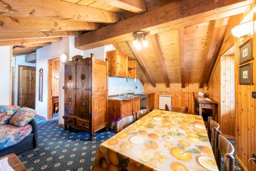 尚波吕克圣塔桑酒店的带桌子的厨房,位于带木制天花板的房间内