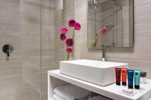 佛罗伦萨佛罗伦萨格兰斯酒店的浴室设有白色水槽和粉红色的鲜花