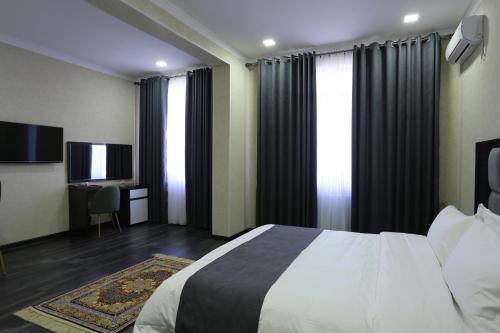 杜尚别Hotel 777的酒店客房,配有床和电视